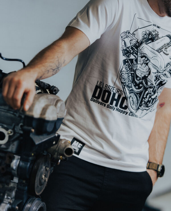 Engine repair enthusiast working on a car engine in a garage.