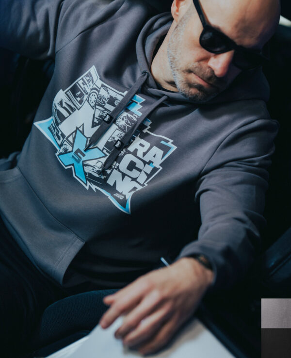 A man wearing a gray hoodie with the MiataFamily.com logo, sunglasses, and a focused expression, sitting in a car.