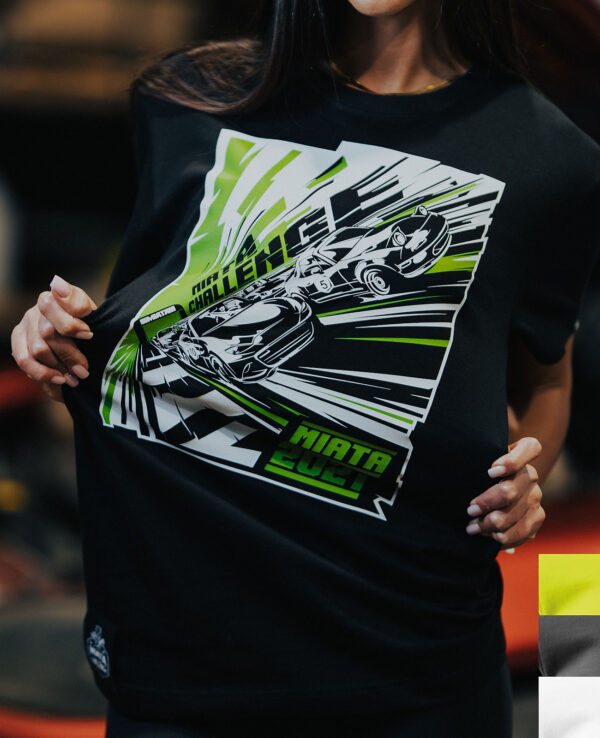 Woman wearing a Miata Challenge 2024 T-shirt featuring dynamic car graphics in black, green, and white, promoting Mazda Miata racing events.