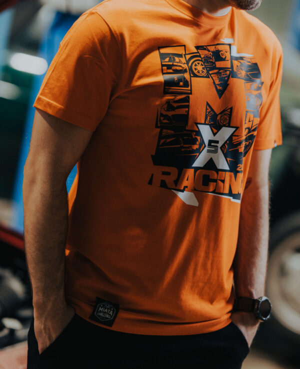 Close-up of a person wearing an orange Miata racing T-shirt with a graphic design and logo, showcasing car racing enthusiasm.