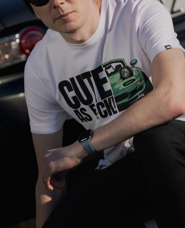 Car enthusiast T-shirt featuring a cute green Miata illustration and bold "CUTE AS F*CK" text. Perfect for Mazda MX-5 fans and car lovers.